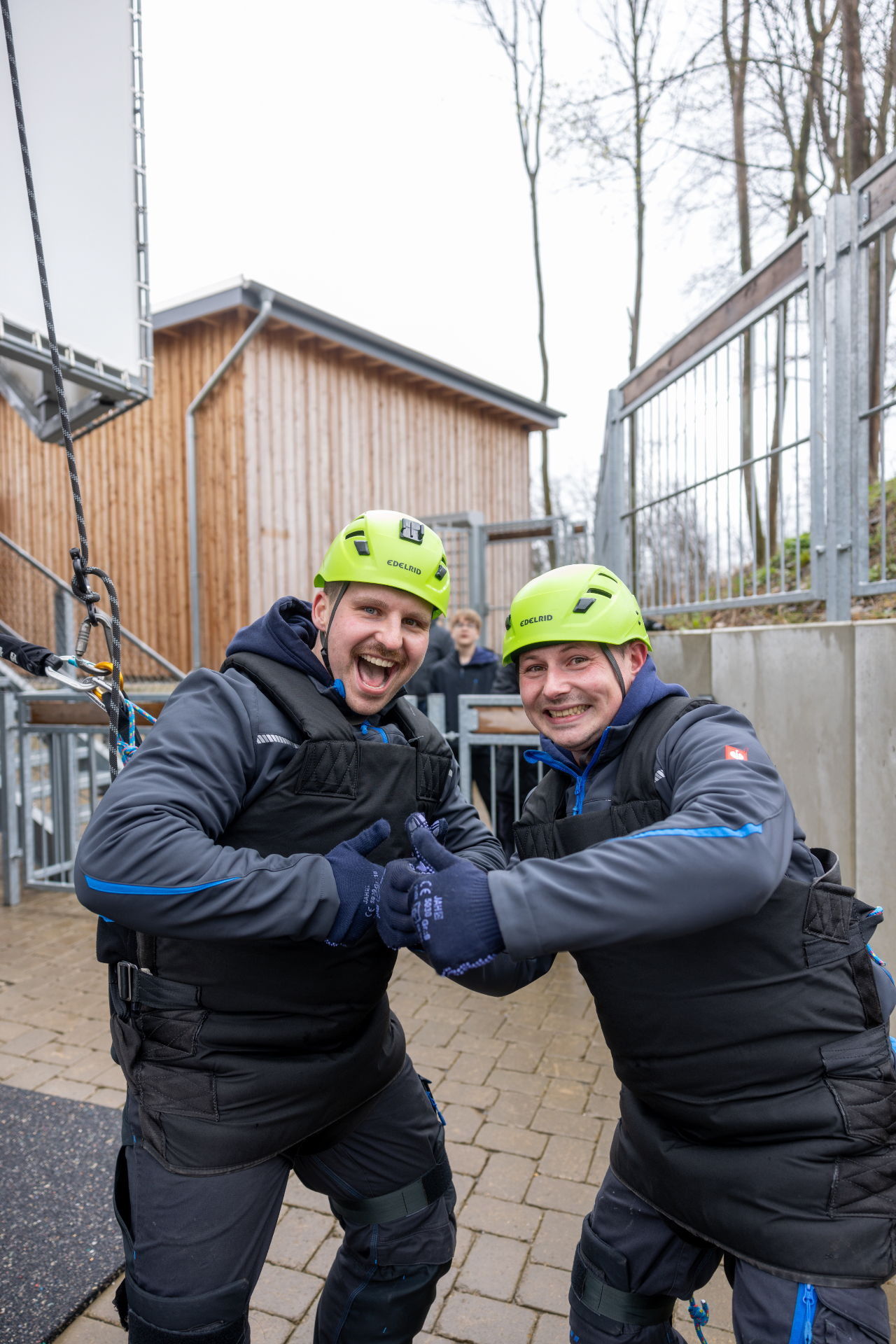 Zwei lachende Teammitglieder mit gelben Helmen