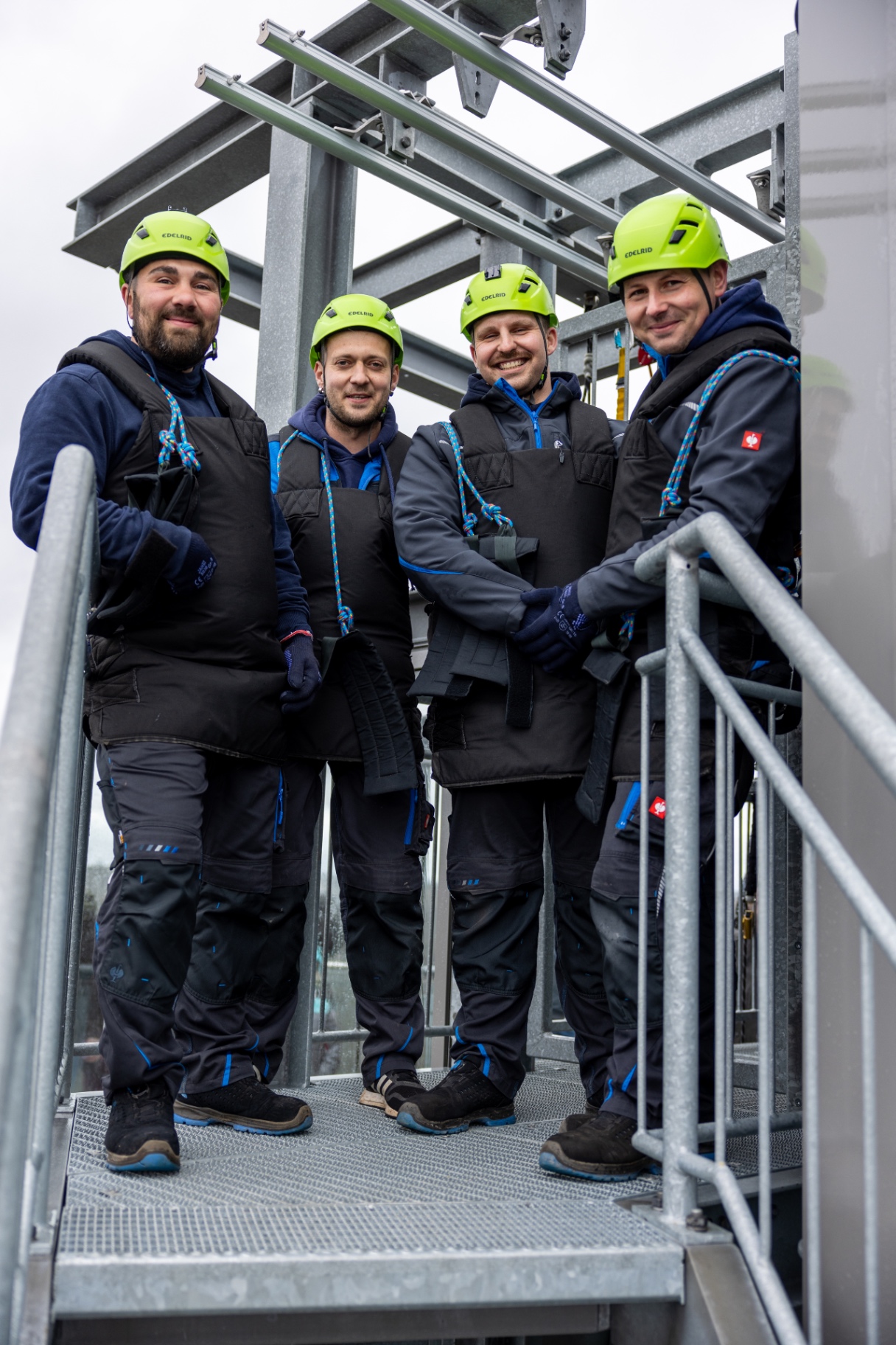 Vier Teammitglieder mit gelben Helmen auf dem Aussichtsturm Solitär